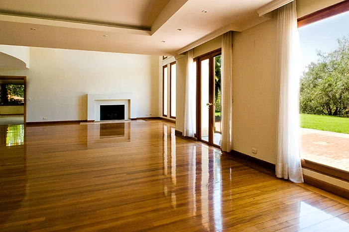 Leerer heller Raum mit Holzboden und Terrassentür